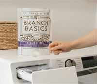 Person opening a washing machine with Branch Basics Laundry Detergent in the foreground. - Thumbnail View 6
