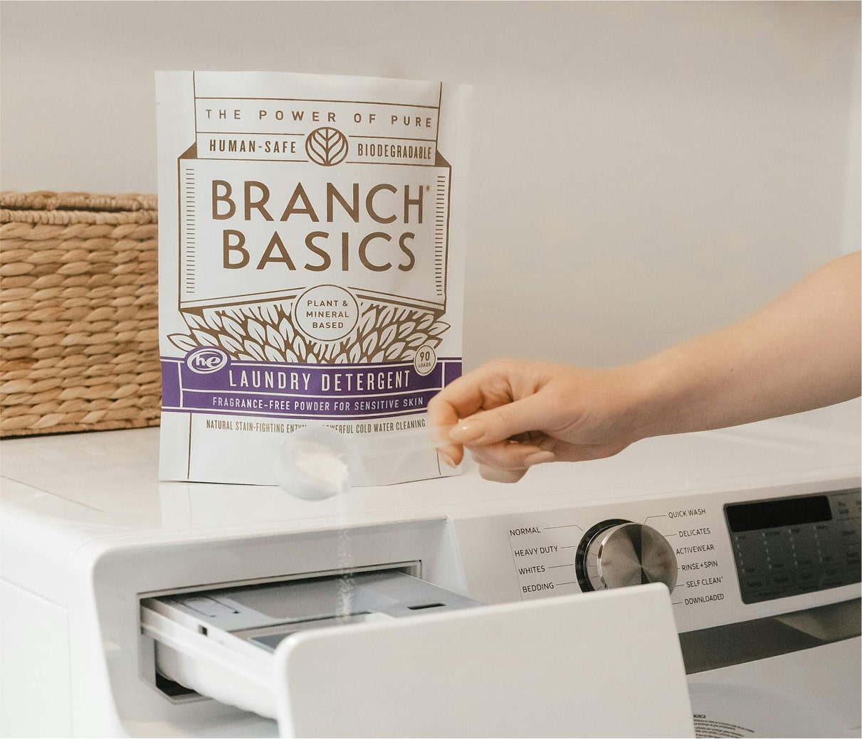Person opening a washing machine with Branch Basics Laundry Detergent in the foreground. - View 6
