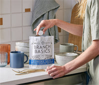 A standing bag of Dishwasher Tablets with a hand extracting a single Dishwasher Tablet from the bag. - Thumbnail View 7
