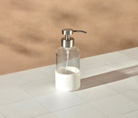 A single refillable Glass Foaming Wash Bottle with a Brushed-Chrome pump, displayed on a white surface and neutral background. - Thumbnail View 2

