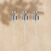 A trio of Brushed Chrome Foaming Wash Pumps for Glass bottles, displayed on a neutral background. - Thumbnail View 1
