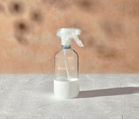A refillable Glass Streak-Free bottle, used to dilute and dispense Branch Basics Concentrate with water, displayed on a white surface and neutral background. - Thumbnail View 2
